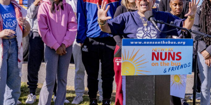 Ana Garcia-Ashley, bus rider and Executive Director of Gamaliel, speaks movingly at the Vote Our Future tour closing rally, with young people behind her. 